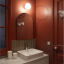 White porcelain wall light with glass globe for bathroom or outdoor use.