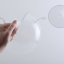 White porcelain wall light with glass globe for bathroom or outdoor use.