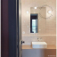 White porcelain wall light with glass globe for bathroom or outdoor use.