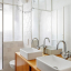 White porcelain wall light with glass globe for bathroom or outdoor use.