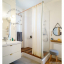 White porcelain wall light with glass globe for bathroom or outdoor use.