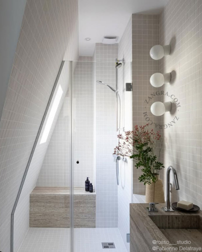 White porcelain wall light with glass globe for bathroom or outdoor use.