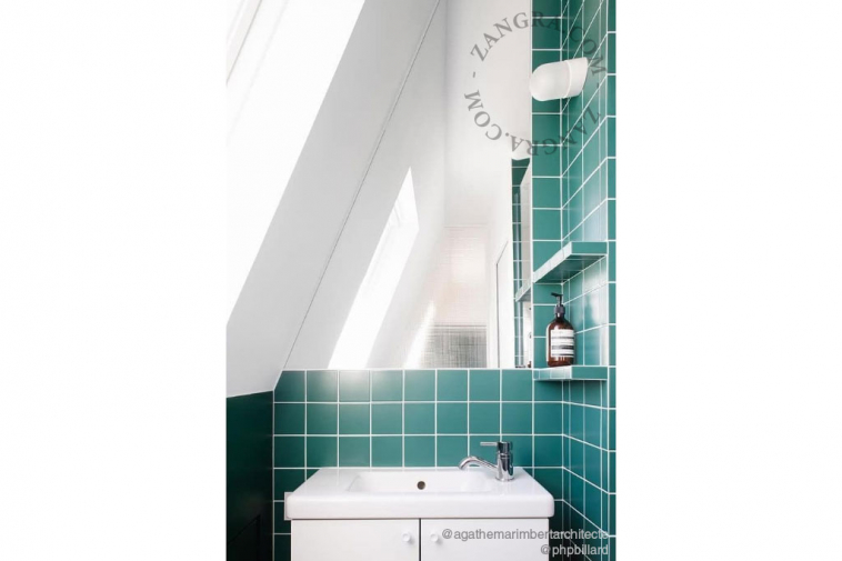 White porcelain wall light with glass globe for bathroom or outdoor use.