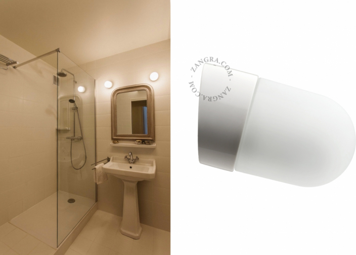 White porcelain wall light with glass globe for bathroom or outdoor use.