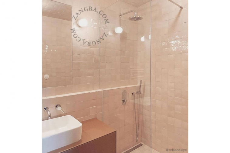 White porcelain wall light with glass globe for bathroom or outdoor use.