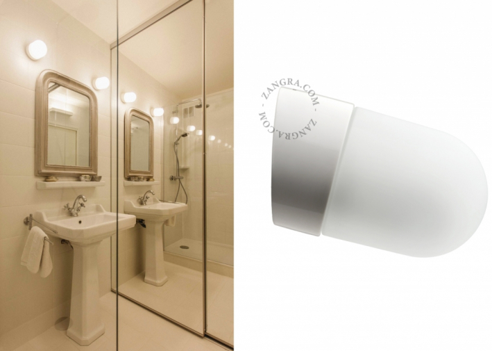 White porcelain wall light with glass globe for bathroom or outdoor use.