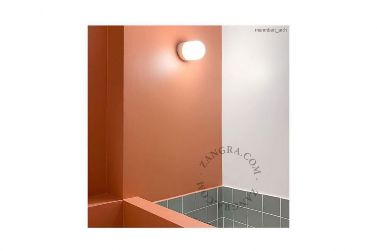 White porcelain wall light with glass globe for bathroom or outdoor use.