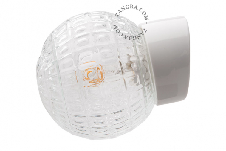 White porcelain wall light with glass globe for bathroom or outdoor use.