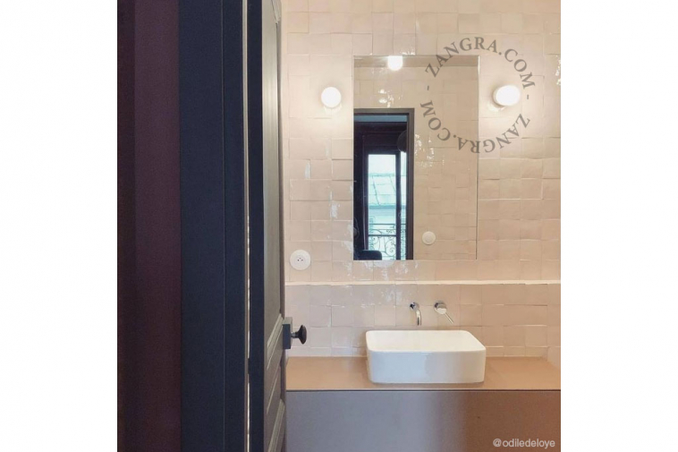 White porcelain wall light with glass globe for bathroom or outdoor use.