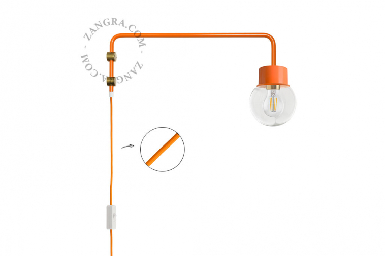 Aplique de pared naranja con brazo giratorio y globo de vidrio.