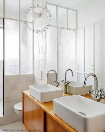 White porcelain wall light with glass globe for bathroom or outdoor use.