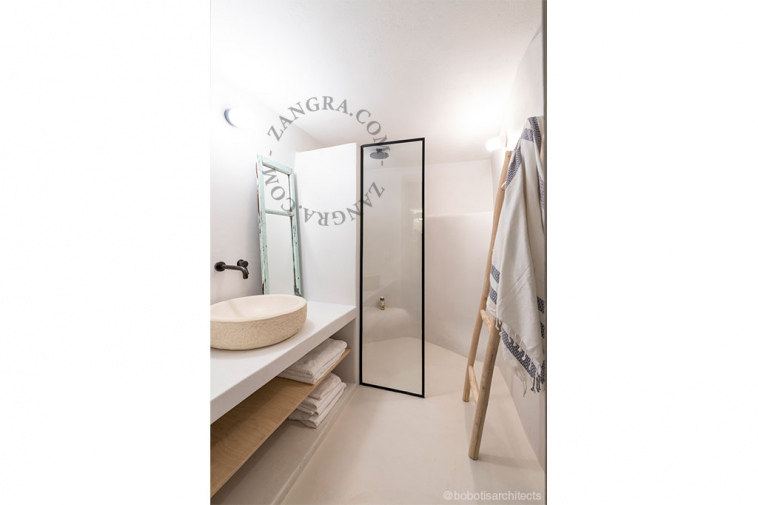White porcelain wall light with glass globe for bathroom or outdoor use.