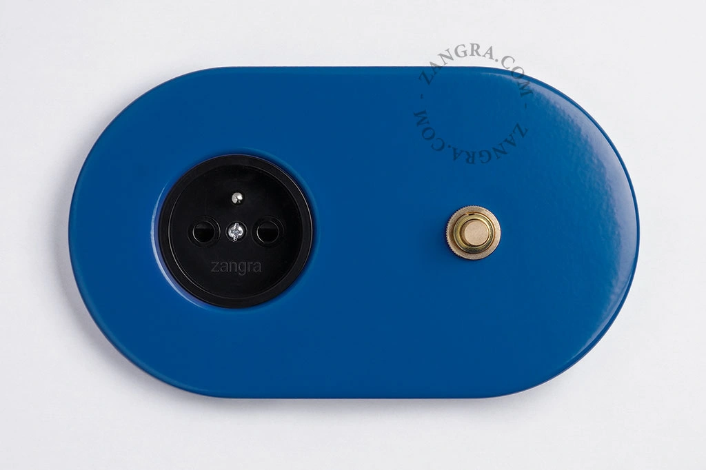 blauw stopcontact met goudkleurige drukknop