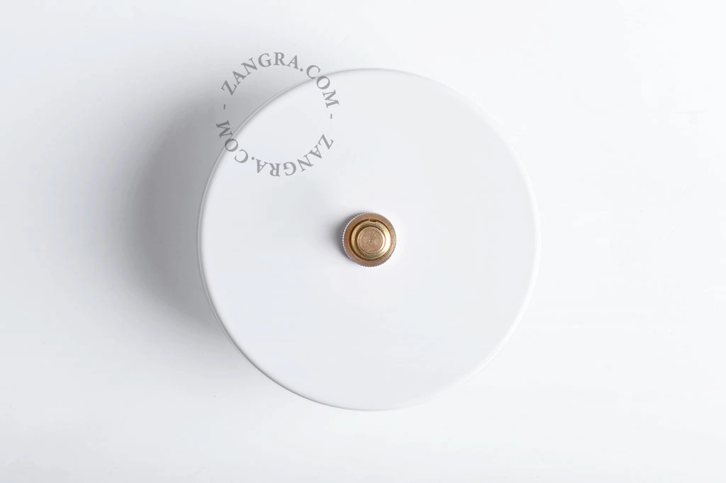 witte schakelaar met goudkleurige drukknop