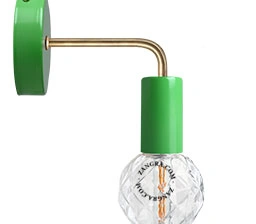 green wall light with brass arm