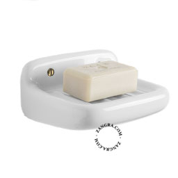 Wall mounted white porcelain soap holder.