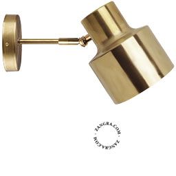 Adjustable wall light in raw brass.