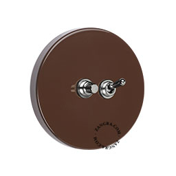Round brown light switch with pushbutton.
