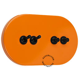 grand interrupteur orange avec 2 leviers ainsi que 2 boutons-poussoirs en laiton noir