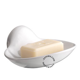 Shell-shaped wall mounted white porcelain soap holder.