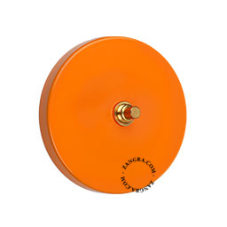 interrupteur bouton-poussoir en laiton brut sur plaque de finition orange
