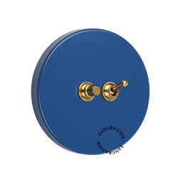Round blue switch with brass toggle and pushbutton.