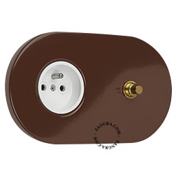 Brown flush mount outlet with raw brass pushbutton.