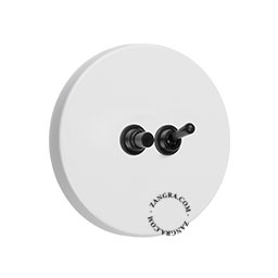 White round light switch with black pushbutton and toggle