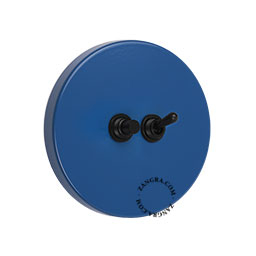 Round blue light switch with black toggle and pushbutton.