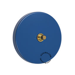 interrupteur bouton-poussoir avec façade en acier bleu et bouton en laiton brut