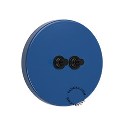 deux boutons-poussoirs en laiton noir sur un interrupteur en acier bleu