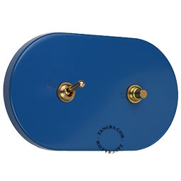 Blue light switch with brass pushbutton and lever.