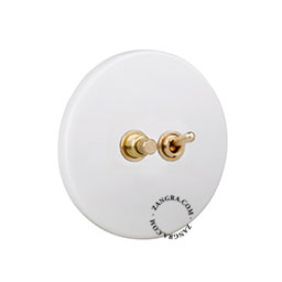 Matte white porcelain switch with brass toggle & pushbutton.