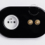2 raw brass push buttons on black flush mount outlet.