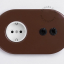 Brown outlet with double toggle switch.