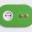 2 gold push buttons on green outlet.