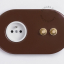 2 gold push buttons on brown integrated outlet