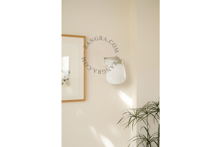 White porcelain wall light with glass globe for bathroom or outdoor use.