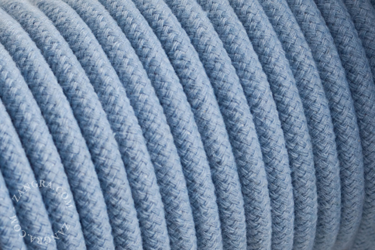 Electrical cable covered in blue cotton.