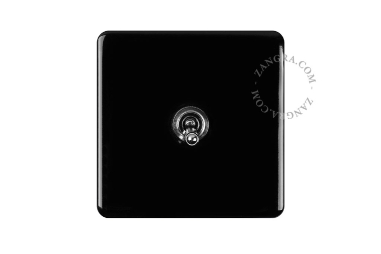 Vierkante lichtschakelaar in zwart porselein met tuimelschakelaar.