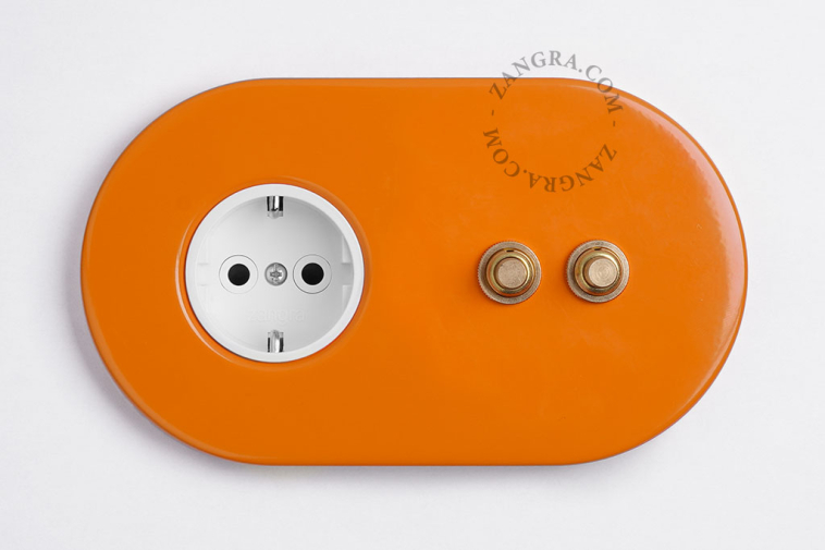 enchufe naranja y doble interruptor pulsador de latón