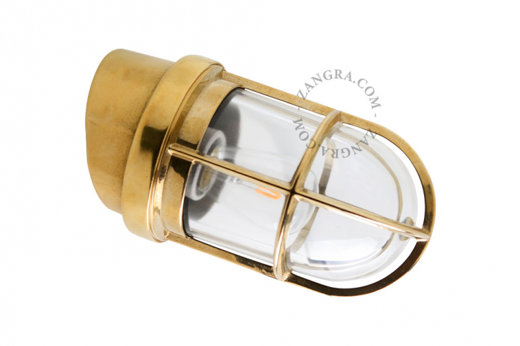Marine-inspired brass wall light with transparent glass.