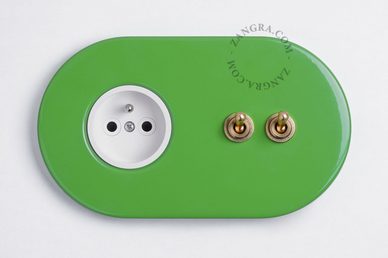 Green flush mount outlet & switch with raw brass double lever.