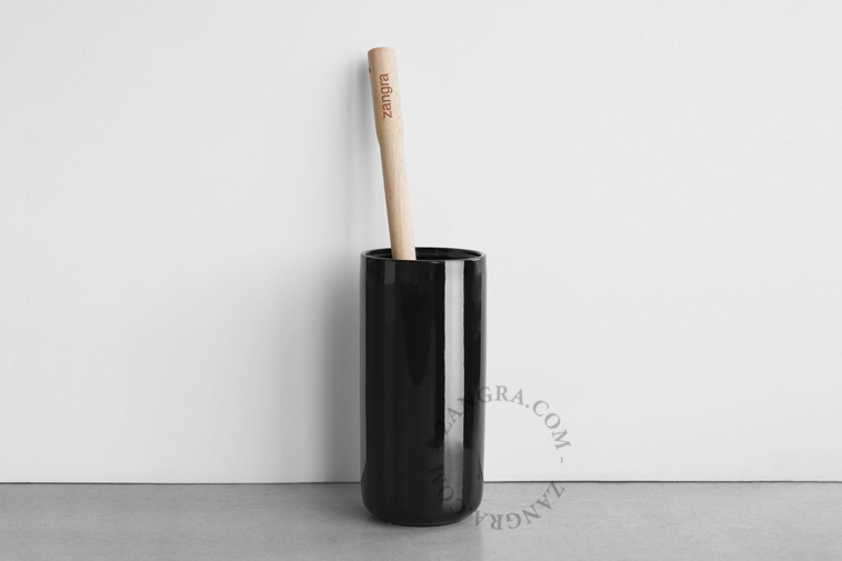 Black porcelain toilet brush holder with wooden brush.