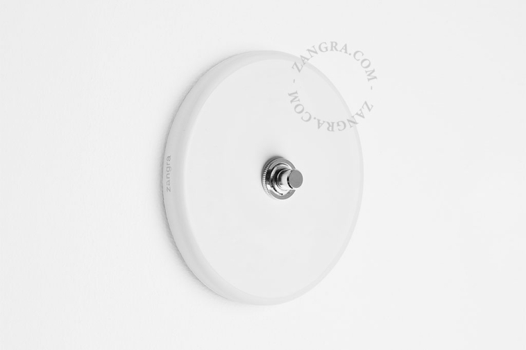 Round white porcelain light switch.