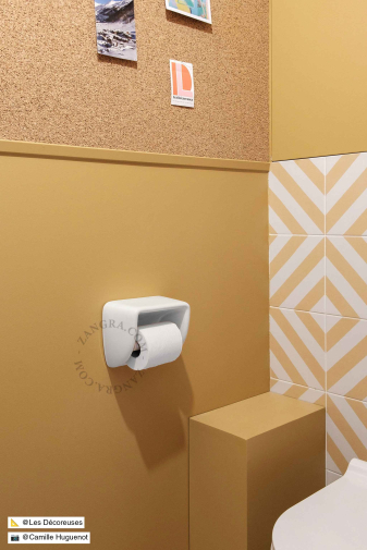 White porcelain toilet paper dispenser.