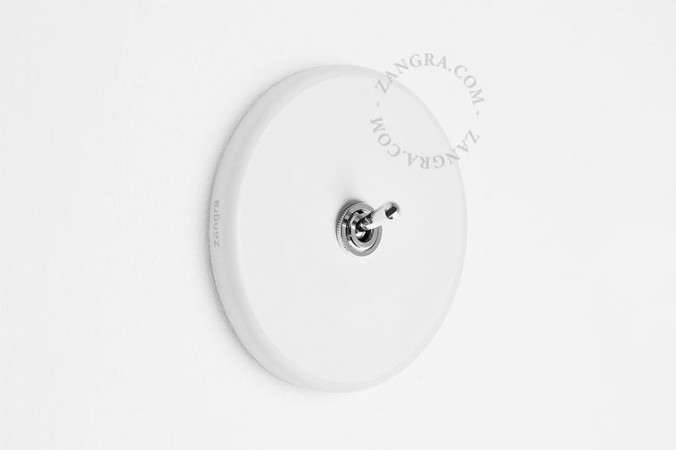 Round white porcelain light switch.