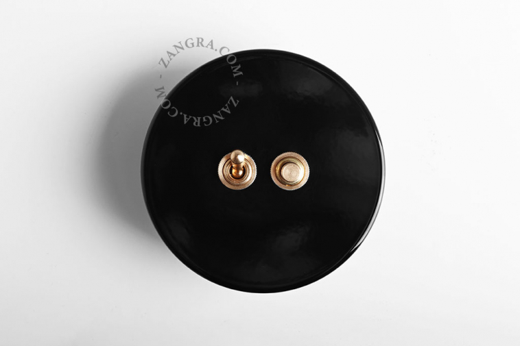 interrupteur noir avec bouton-poussoir et levier en laiton brut