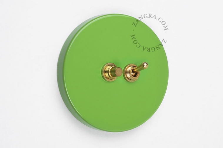 Round green switch with brass toggle & pushbutton.