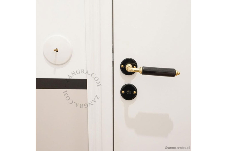 Door handle in black porcelain and brass.